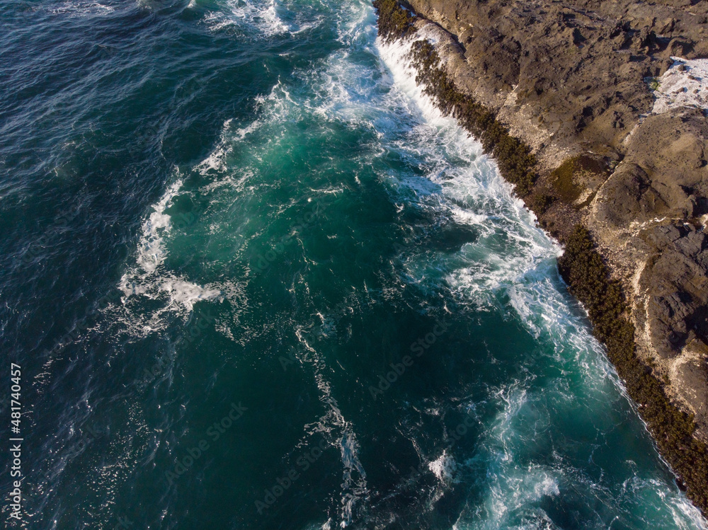 Aerial view. Beautiful seascape. Seething emerald-colored sea water and a brown shore. Beauty of nature, tourism, water travel, sports, fishing, environmental protection, ecology, geology.