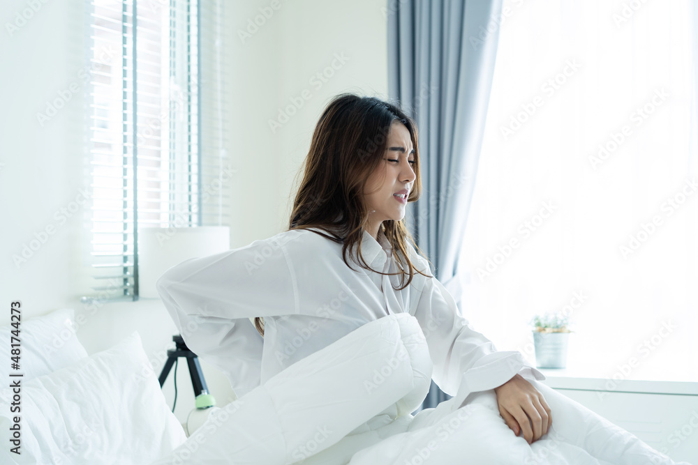 Asian beautiful sick girl in pajamas getting up from sleep in bedroom. Asian beautiful sick girl in pajamas getting up from sleep in bedroom.