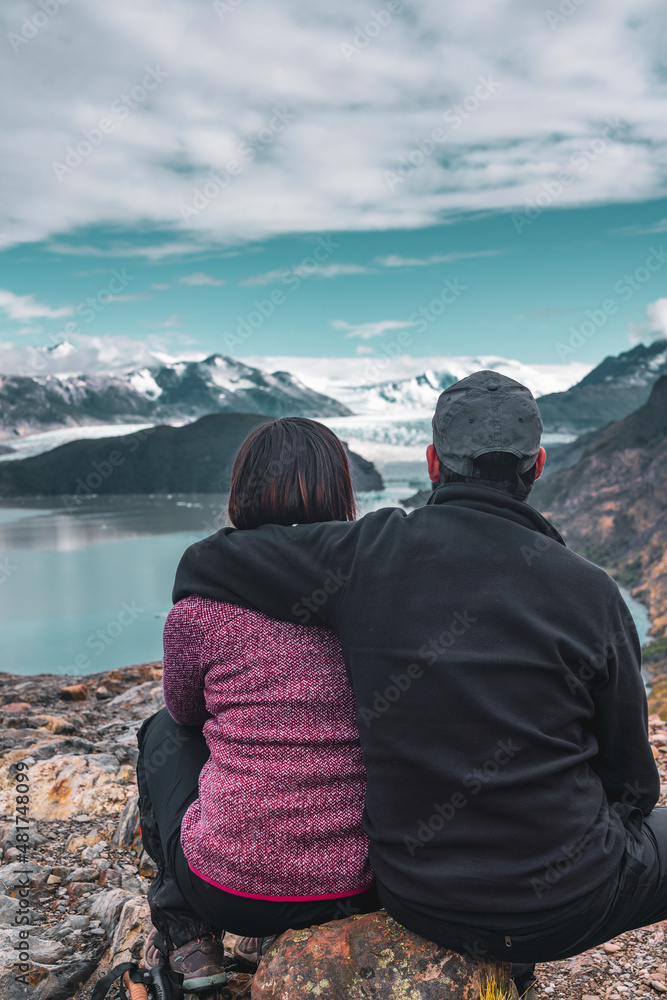 Fototapeta premium Hiking couple resting and looking out at landscape