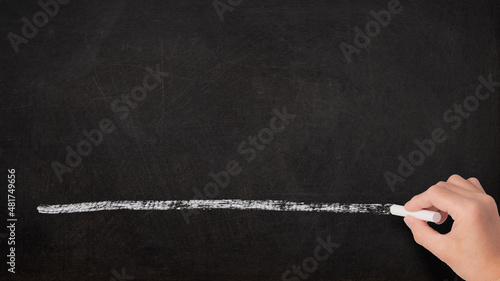 黒板に白いチョークで線を引く手 photo