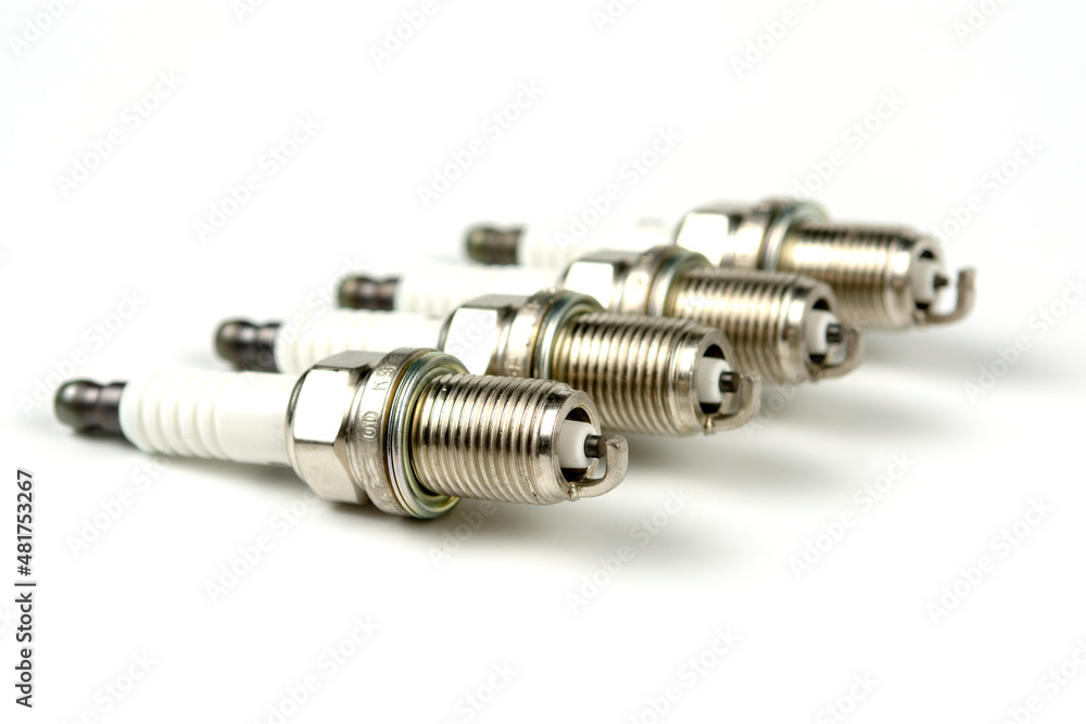 Car service. A set of new car spark plugs as a spare part of motor vehicles on white. Group of candles for the motor close-up Car service. A set of new car spark plugs as a spare part of motor vehicles on white. Group of candles for the motor close-up