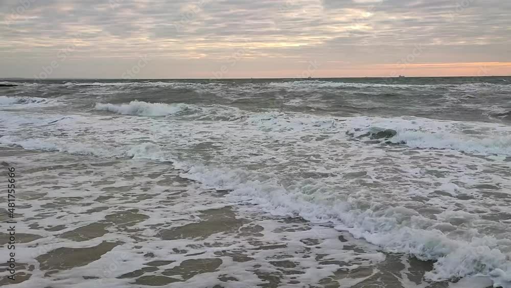 Landscape sea waves white foam storm wind blue sky skyline flying seagulls on sunny day. Beach shore sea coast seashore in city Landscape sea waves white foam storm wind blue sky skyline flying seagulls on sunny day. Beach shore sea coast seashore in city