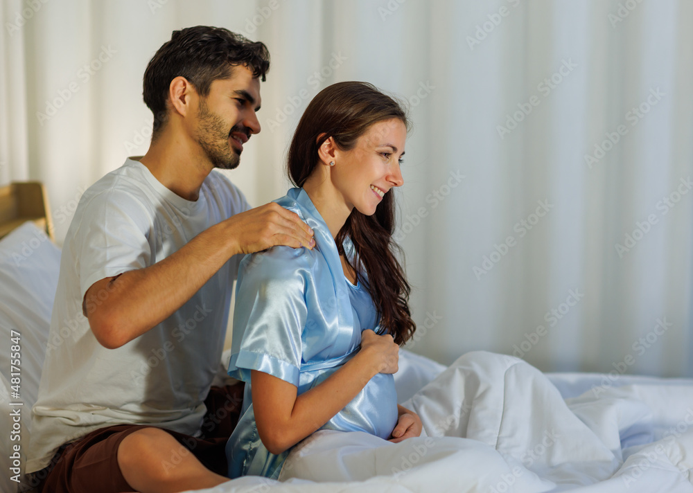 Lovely husband tenderly massage shoulder of beloved pregnant wife who happy for love therapy before night sleep on bed to release stress and pain Lovely husband tenderly massage shoulder of beloved pregnant wife who happy for love therapy before night sleep on bed to release stress and pain