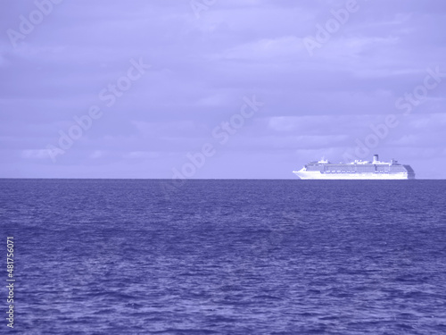 Beautiful seascape with a lonely ship in the trendy very peri color of the year.