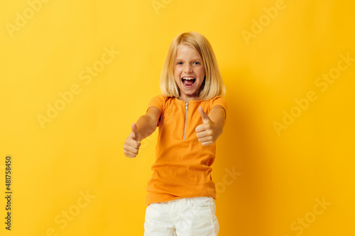 kid girl in a yellow t-shirt smile posing studio color background unaltered