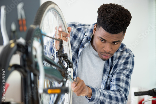 male mechanic making adjustment to bicycle