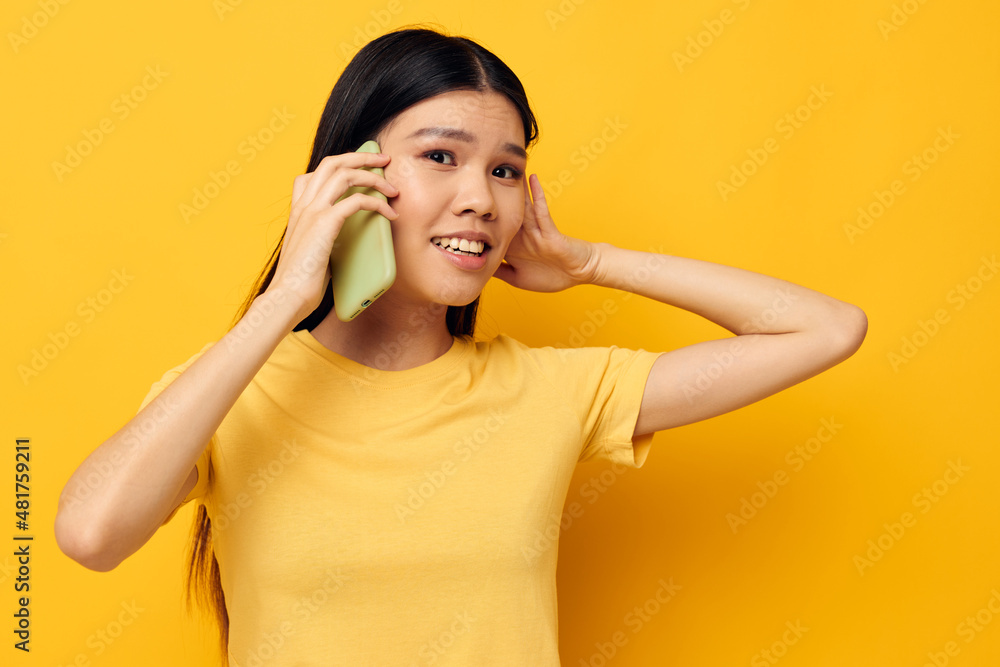 pretty brunette talking on the phone posing technology yellow background unaltered pretty brunette talking on the phone posing technology yellow background unaltered