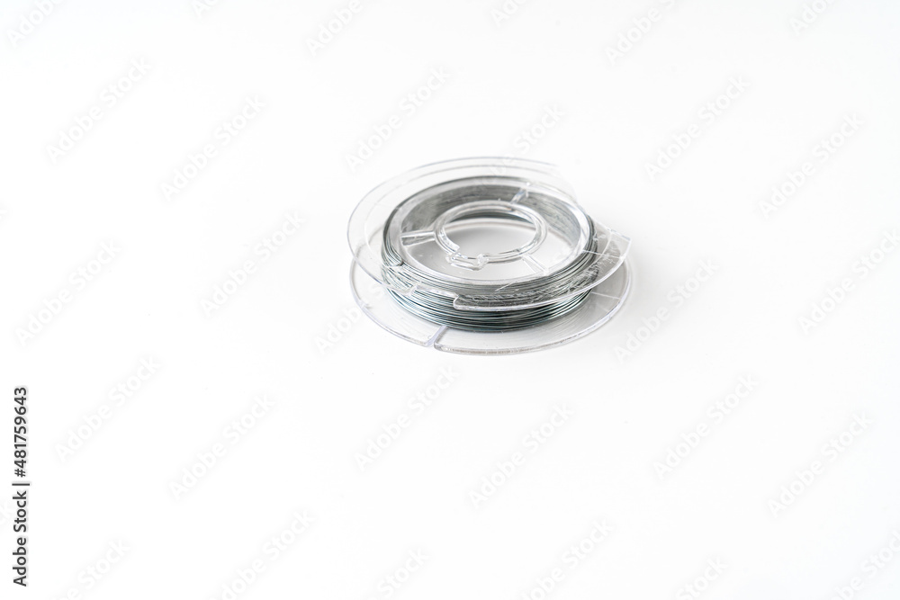 wire coil for weaving and needlework from beads on a white background. accessories for creating costume jewelry. sale of goods for creativity and needlework. wire coil for weaving and needlework from beads on a white background. accessories for creating costume jewelry. sale of goods for creativity and needlework.