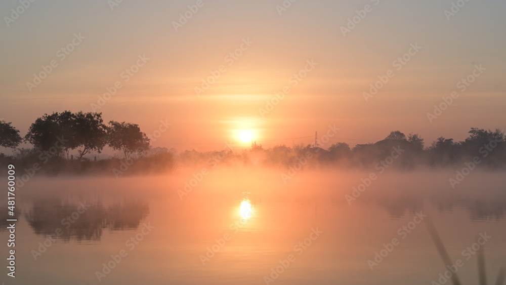 Trees and white clouds on blue sky with reflective in the water.Natural landscape in the morning time.
