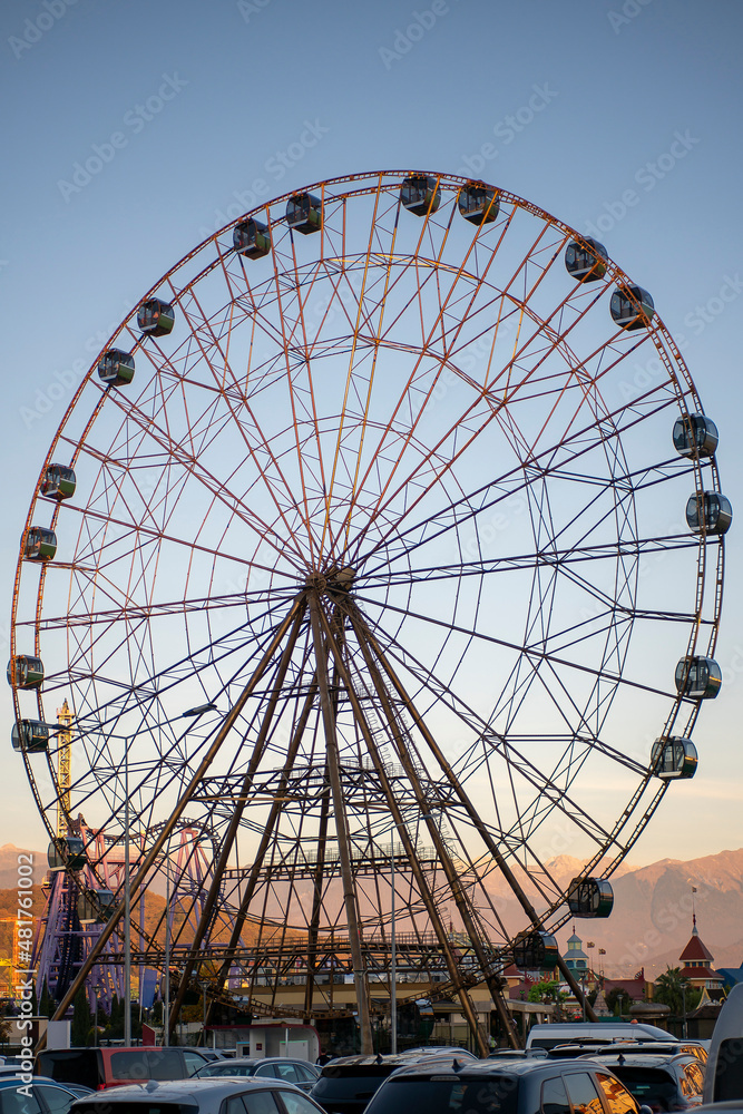 Big Ferris wheel in the rays of sunset.