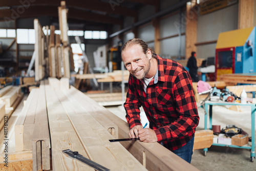 Male carpenter in a woodworking workshop or factory