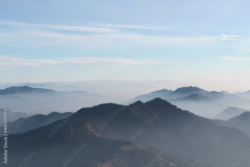 Abstract natural background with sky and mountains in the evening haze.