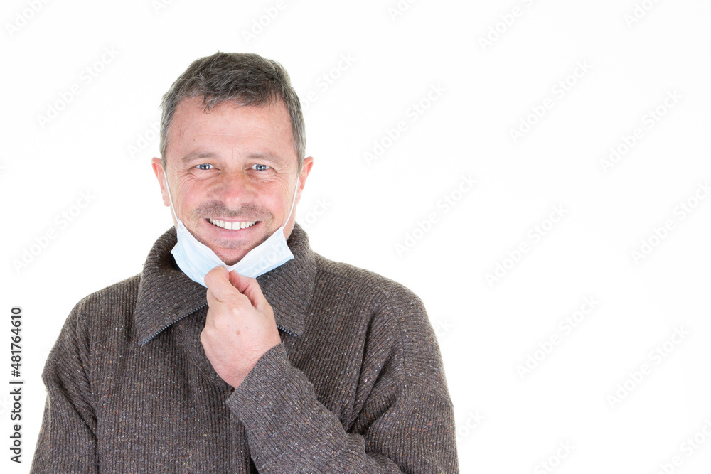 smiling happy man takes off his mask stop covid-19 infection fabric protection isolated over white background smiling happy man takes off his mask stop covid-19 infection fabric protection isolated over white background