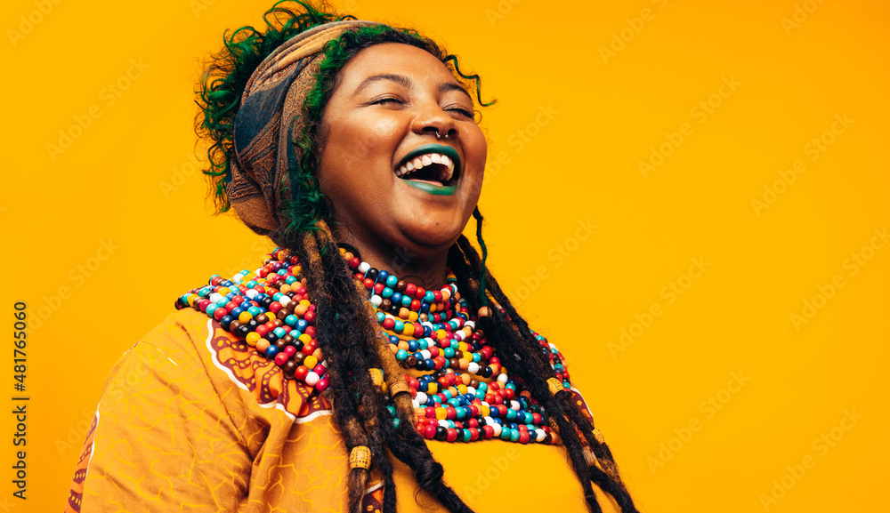 Obraz premium Cheerful ethnic woman laughing while wearing African traditional clothing