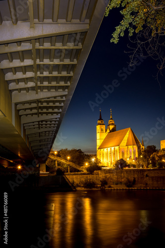 illuminated church is reflected in the river in the evening hours