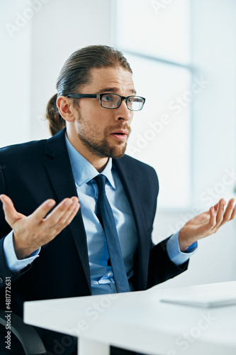 business man in a suit sitting at his desk tired in front of a computer