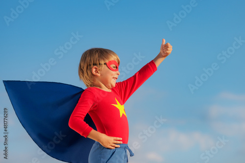 Superhero child against summer sky outdoor