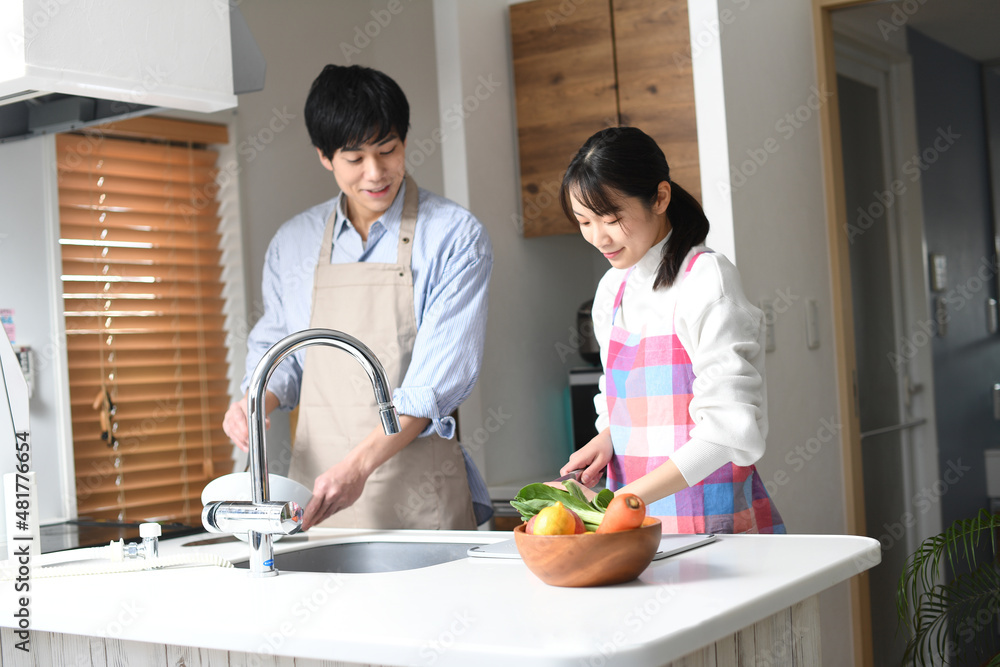 キッチンで料理をする若い夫婦(カップル)のイメージ キッチンで料理をする若い夫婦(カップル)のイメージ