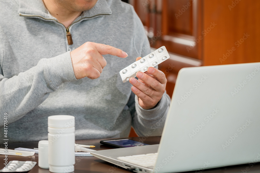 Fototapeta premium Middle-aged Asian male receiving telemedicine at home.
