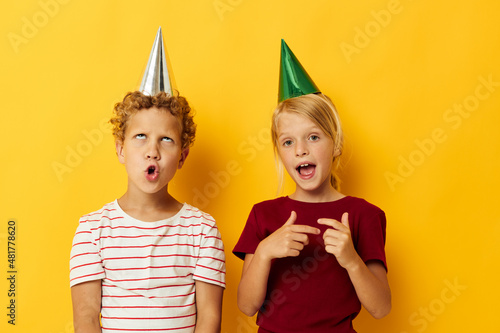 picture of positive boy and girl holiday fun with caps on your head isolated background