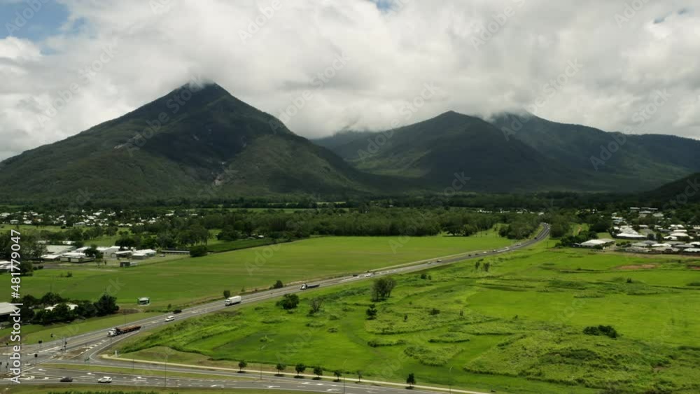 Aerial shot showing traffic on rural Australian road with vegetated mountains in background Aerial shot showing traffic on rural Australian road with vegetated mountains in background