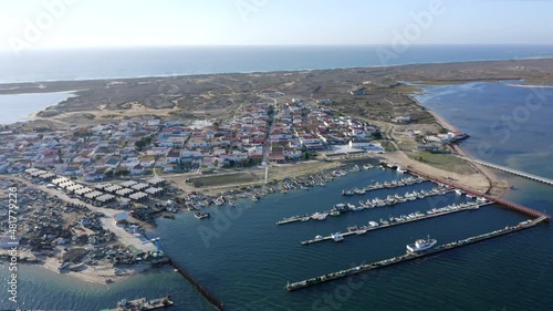 Boats Moored At Culatra Island Pier With Seaside Village At Daytime In Algarve, Faro, Portugal. - aerial