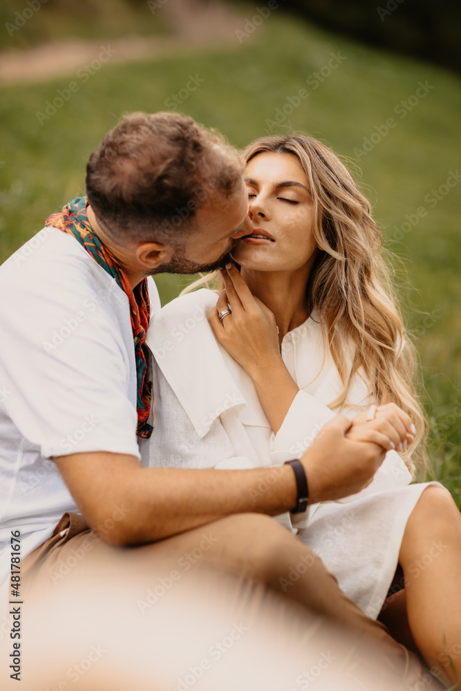 Fototapeta premium Young couple deeply in love laughing and cuddling, enjoying the time spent in nature