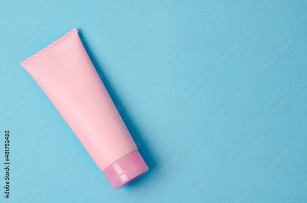 Empty a cosmetic pink tube of cream on blue background Empty a cosmetic pink tube of cream on blue background