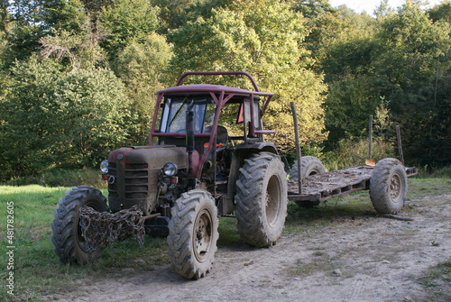 stary traktor z przyczepą do zwózki drewna