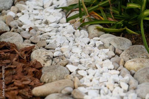 the use of natural materials in landscape design. Pine bark, white stones and pebbles as decoration of the green area in the city.