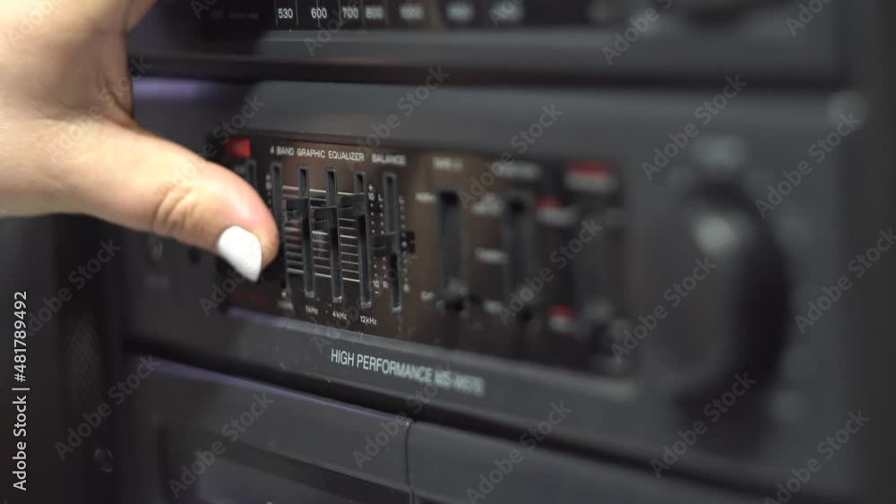 Equalizer setting. Cassette recorder. Finger. Dark body. Retro electronics. Old fashioned design. Analog control. Close-up. Equalizer setting. Cassette recorder. Finger. Dark body. Retro electronics. Old fashioned design. Analog control. Close-up.