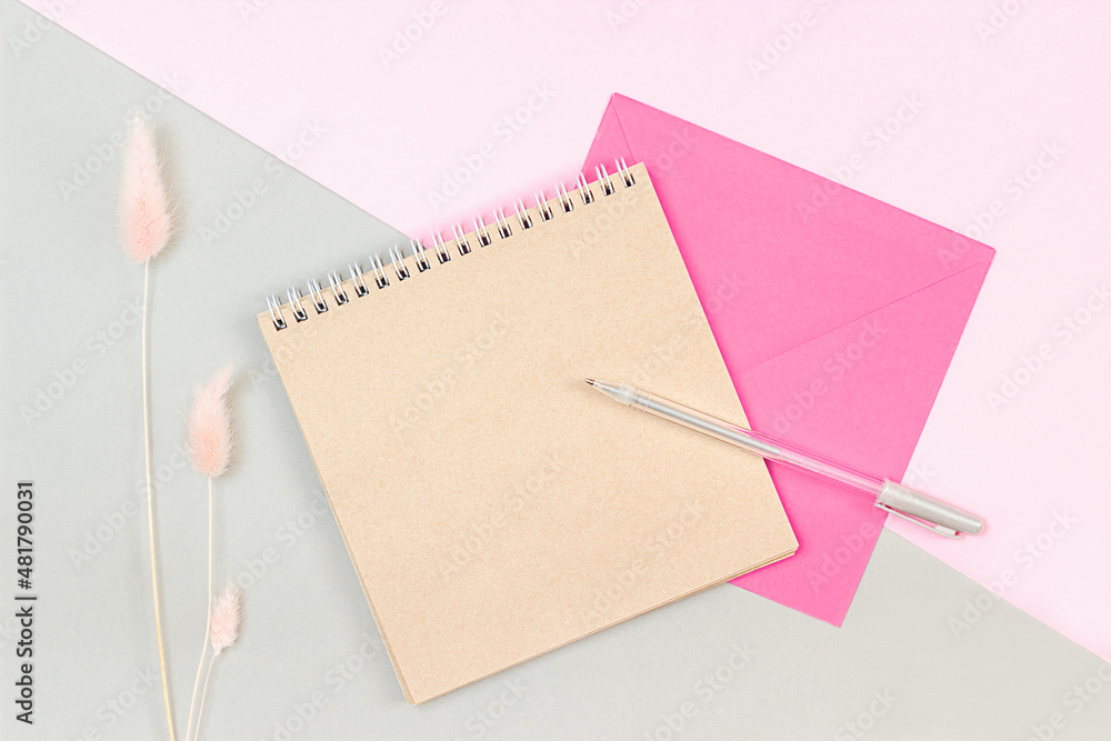 blank notepad and envelope lie on a pink gray background blank notepad and envelope lie on a pink gray background