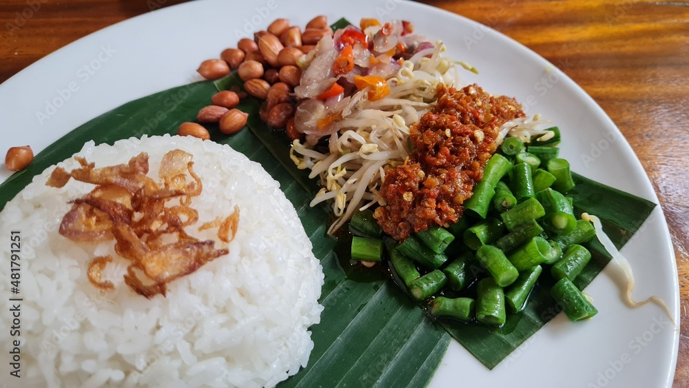 Nasi Ayam Bakar Taliwang or Grill Taliwang Chicken, is a traditional food from Lombok, Mataram Indonesia. Served with Plecing kangkung or water spinach. Top view. Nasi Ayam Bakar Taliwang or Grill Taliwang Chicken, is a traditional food from Lombok, Mataram Indonesia. Served with Plecing kangkung or water spinach. Top view.