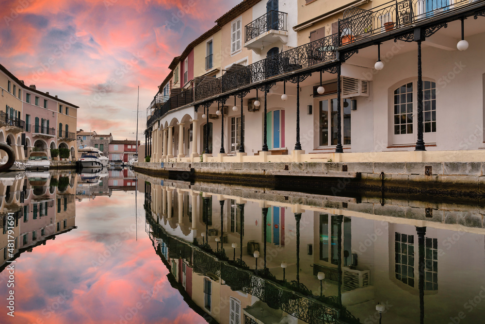 Reflection of the dramatic sunset sky on the canals of the Port Grimaud in Saint Tropez, French Riviera.