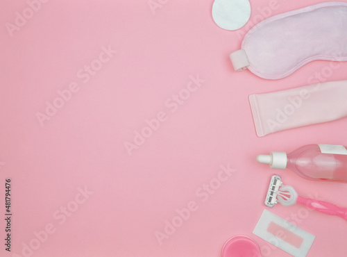 layout of items for face and body care on a pink background, cleansing gel, serum, face roller, guasha, razor, mask, cotton pad, balm, wax strip, pink, flat lay