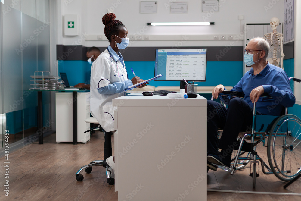 Therapist woman doctor with face mask against coronavirus writing sickness expertise on clipboard explaining healthcare treatment during medical examination in hospital office. Medicine concept