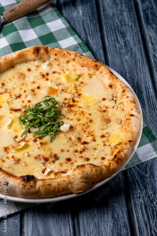 Tasty sliced pizza with fresh arugula and different kinds of cheese. Four cheese pizza, pizza Margarita. Tasty sliced pizza with fresh arugula and different kinds of cheese. Four cheese pizza, pizza Margarita.