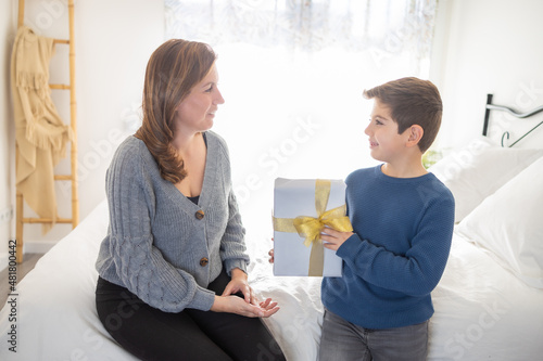 Cute boy giving a gift to his mother on Mothers Day