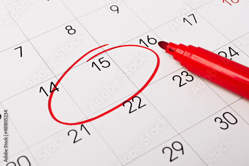 Calendar page with red pen close up. Focus on number 15 in calendar and empty red circle for design in your ideas and work concept