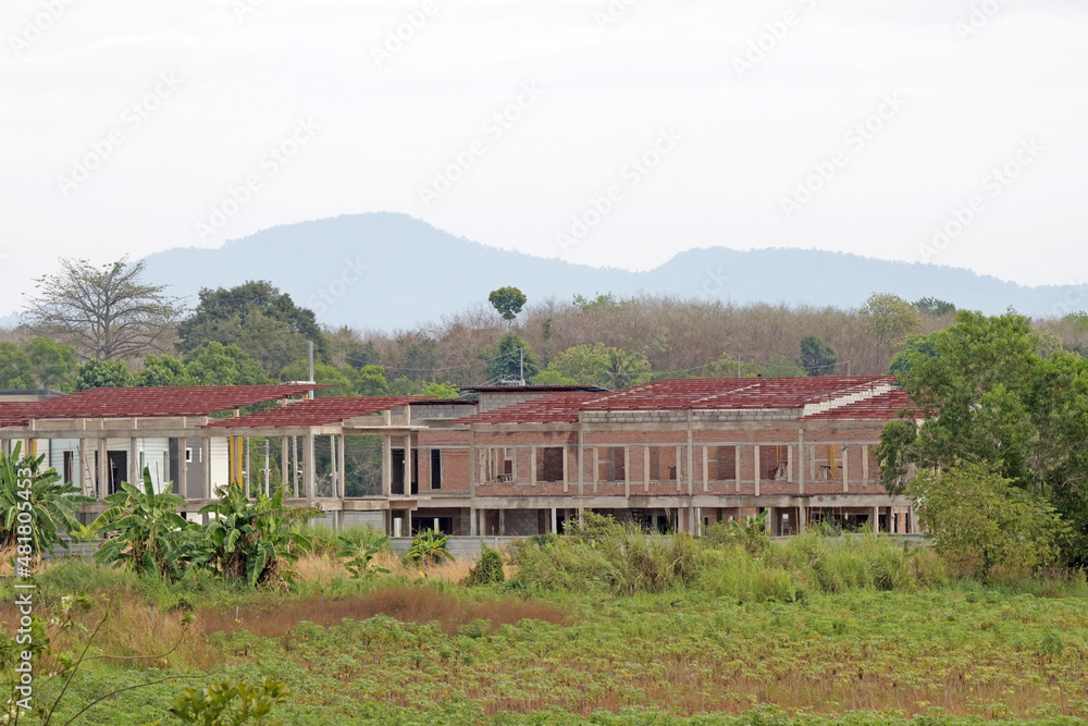 Row of terraced houses under construction in a tropical countryside setting Row of terraced houses under construction in a tropical countryside setting