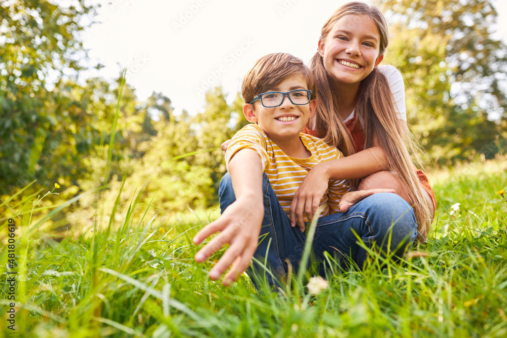 Fototapeta premium Zwei Kinder als Bruder und Schwester im Park