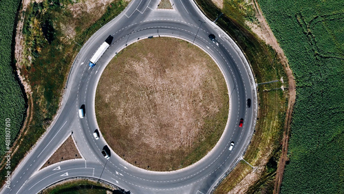 Roundabout traffic of cars and trucks on the circle ring road aerial top view