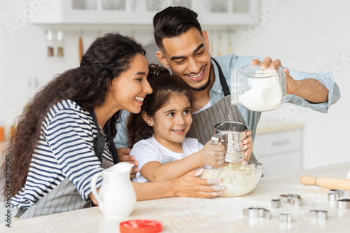 Joyful middle-eastern family making homemade cookies together