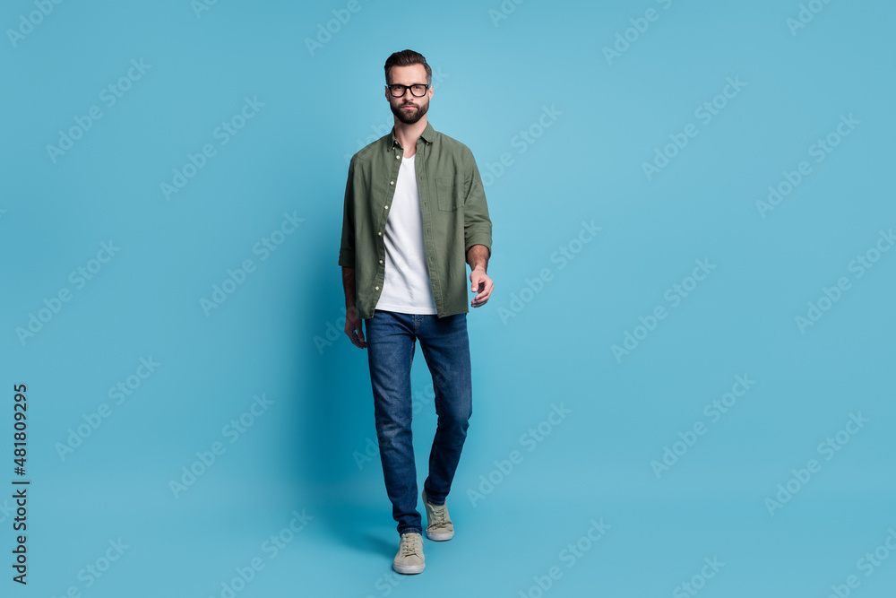 Full size photo of handsome confident serious businessman go walk traveling isolated on blue color background Full size photo of handsome confident serious businessman go walk traveling isolated on blue color background