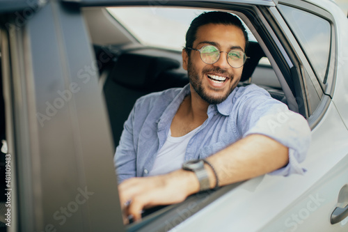 Cheerful arab guy passenger enjoying car ride