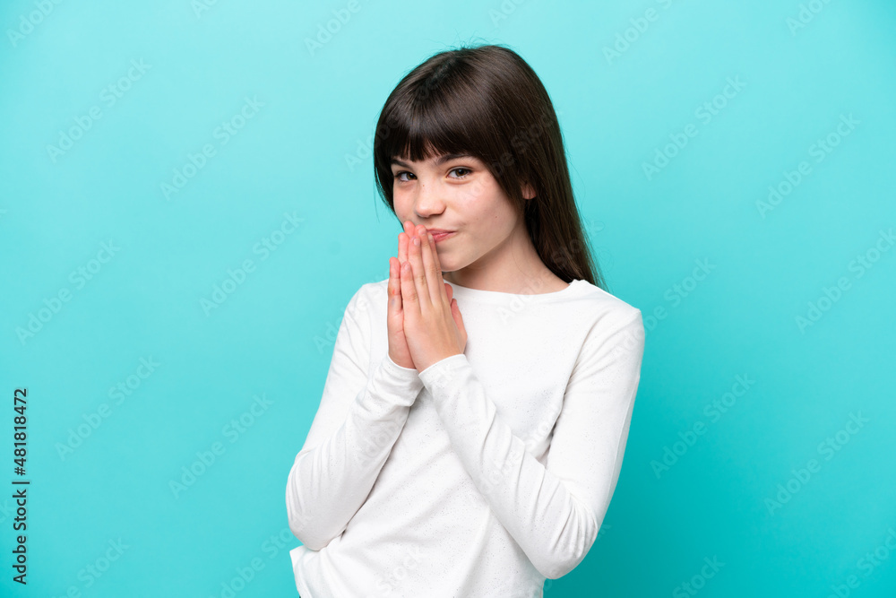 Little caucasian girl isolated on blue background keeps palm together. Person asks for something Little caucasian girl isolated on blue background keeps palm together. Person asks for something