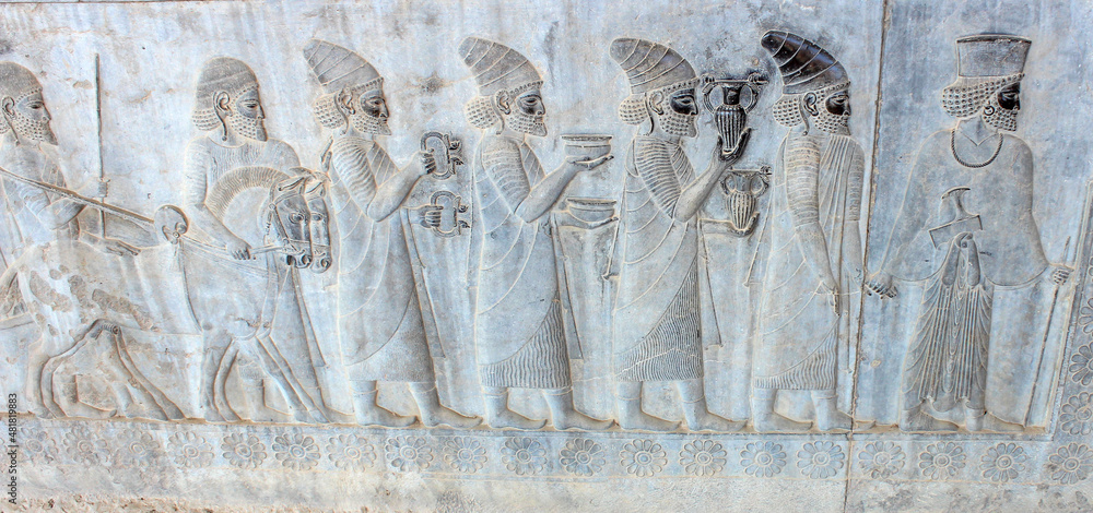 Ancient wall in Persepolis with bas-relief with Phoenician people with gifts and donations for Persian king