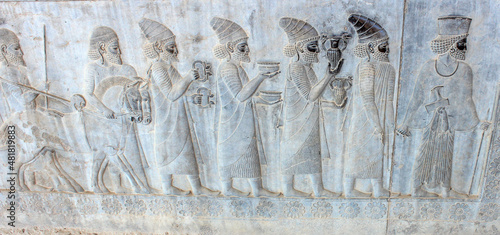 Photos Ancient wall in Persepolis with bas-relief with Phoenician people with gifts and