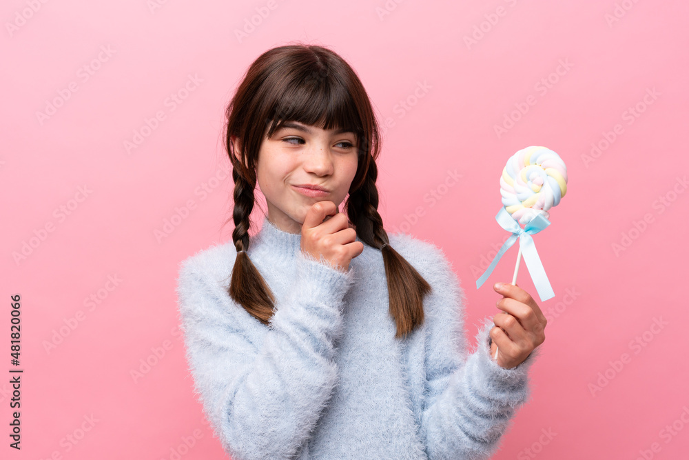 Little caucasian girl holding a lollipop and looking up Little caucasian girl holding a lollipop and looking up