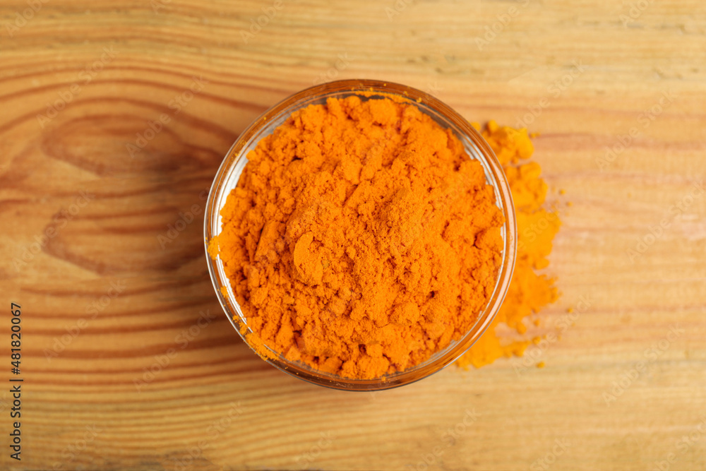Aromatic saffron powder in bowl on wooden table, top view Aromatic saffron powder in bowl on wooden table, top view